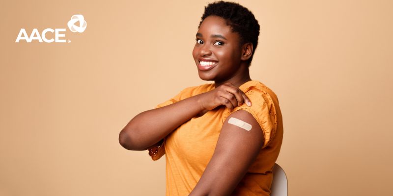 Black woman showing bandaid from vaccine injection on her arm