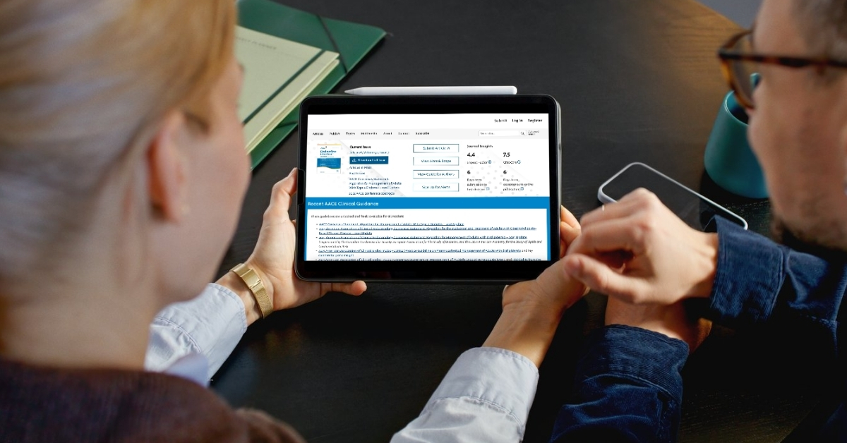 Two people reading AACE's Endocrine Practice (EP) publication on a tablet
